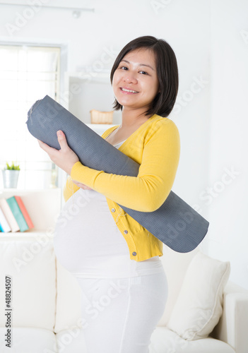 Photo: Asian pregnant woman holding yoga mat Asian pregnant woman holding yoga mat