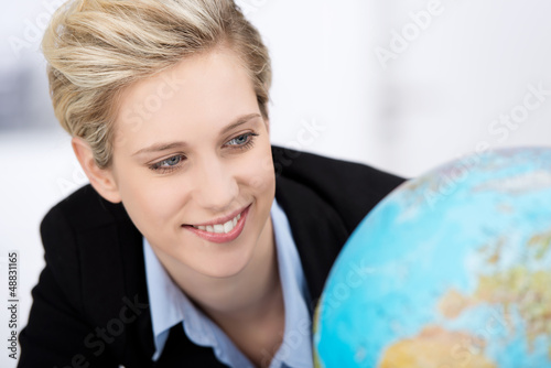 Photo: moderne junge frau schaut auf weltkugel moderne junge frau schaut auf weltkugel