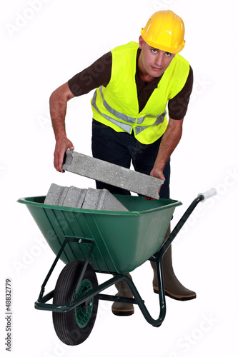 Photo: Mason carrying bricks in wheel barrow Mason carrying bricks in wheel barrow