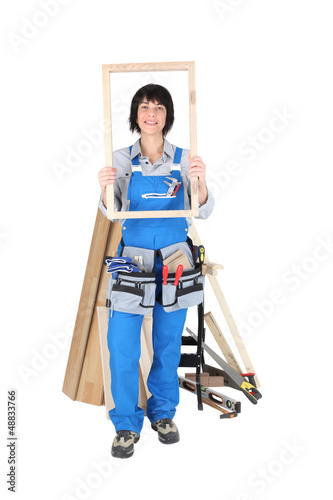 Photo: Female carpenter with a wooden frame Female carpenter with a wooden frame