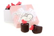 Handmade chocolates and pink box with a bow.