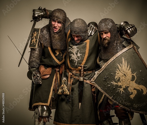 Photo: Two medieval knights carrying their buddy Two medieval knights carrying their buddy