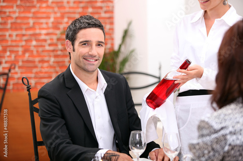 Photo: Waitress bringing wine to customer Waitress bringing wine to customer