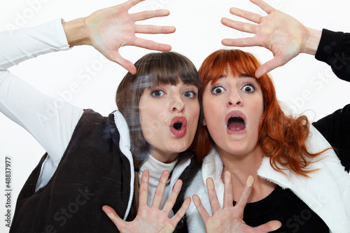 Photo: Two friends pressing their face on a pane. Two friends pressing their face on a pane.