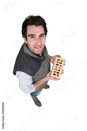 Photo: Handyman holding a brick Handyman holding a brick