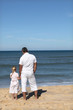 A father and his daughter looking at the sea.