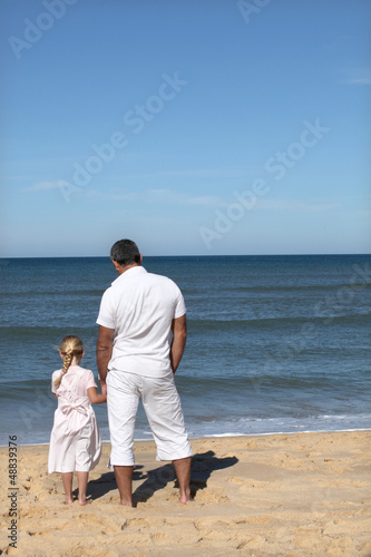 Photo: A father and his daughter looking at the sea. A father and his daughter looking at the sea.