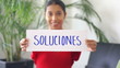 Young woman holding a solutions sign.
