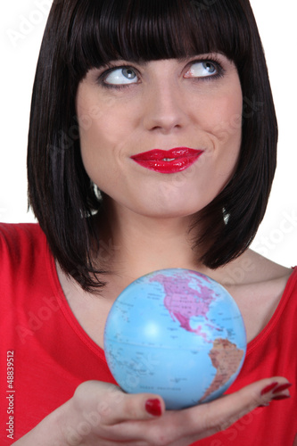 Photo: Woman in red holding planet earth Woman in red holding planet earth