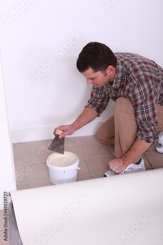 Photo: Man sticking carpet Man sticking carpet
