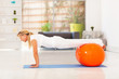 middle aged woman doing push ups with exercise ball