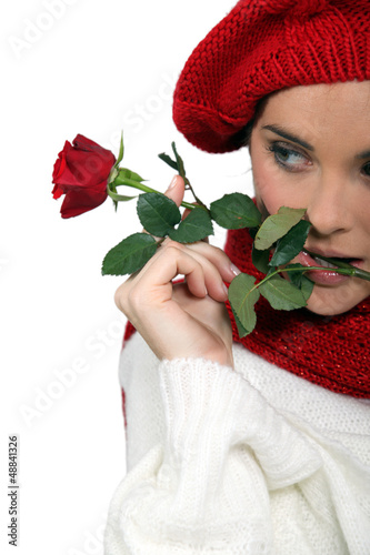 Photo: Woman dressed for winter holding rose Woman dressed for winter holding rose