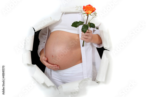 Photo: Pregnant woman holding flower Pregnant woman holding flower