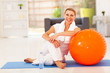 happy senior woman resting on mat after exercise at home