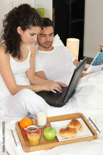 Photo: couple eating breakfast in hotel room couple eating breakfast in hotel room