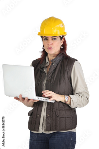 Photo: Female construction worker using her laptop Female construction worker using her laptop