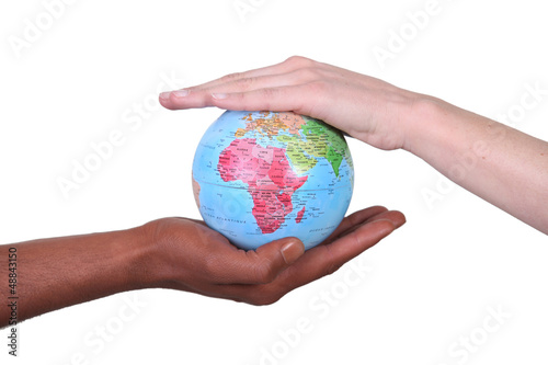 Photo: Two hands touching miniature globe Two hands touching miniature globe