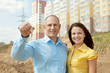 Happy couple against building new house