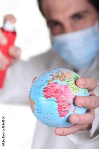 Photo: Doctor holding miniature globe Doctor holding miniature globe