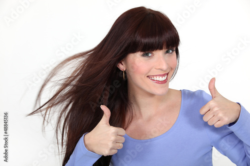 Photo: Brunette giving thumbs-up gesture Brunette giving thumbs-up gesture