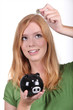 Young woman with a piggy bank