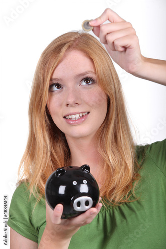 Photo: Young woman with a piggy bank Young woman with a piggy bank