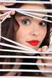 woman looking through window blinds