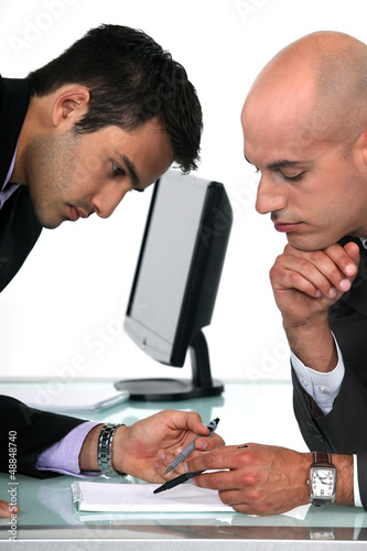 Photo: Two businessmen proof reading final draft of proposal Two businessmen proof reading final draft of proposal