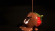 Melted chocolate pouring over a strawberry