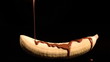 Melted chocolate pouring over a banana