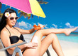 woman in bikini applying sun block cream on body