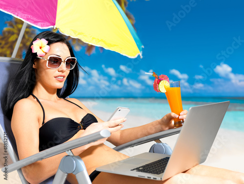 Photo: Woman on the beach with mobile phone Woman on the beach with mobile phone