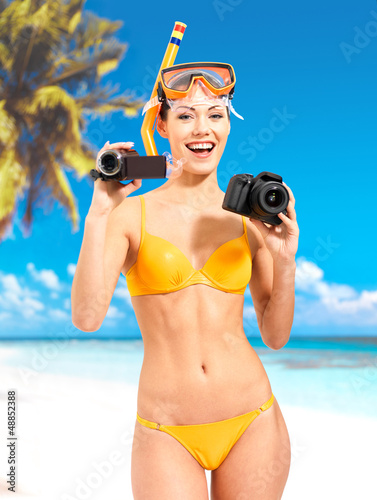 Photo: woman with a photo and video camera on beach woman with a photo and video camera on beach