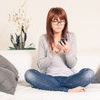 Beautiful Young Woman with Smartphone on the Sofa