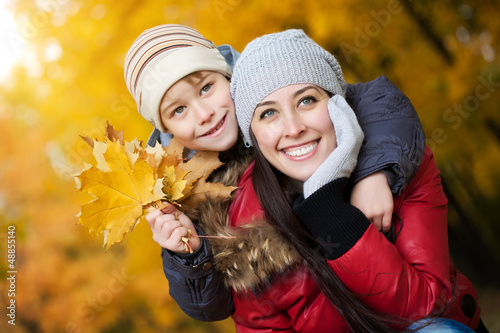 Photo: happy Mom with son in a yellow autumn park happy Mom with son in a yellow autumn park