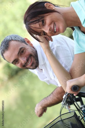 Photo: Couple riding their bikes together Couple riding their bikes together