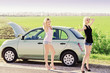 Foto: Two sexy girls standing near their broken car and hitchhiking Two sexy girls standing near their broken car and hitchhiking