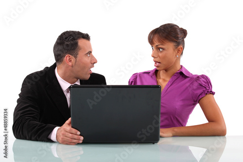 Photo: Business couple shocked at their laptop Business couple shocked at their laptop