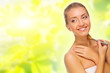 Young woman with makeup brush on spring background