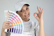 Painter giving the a-ok sign and holding a palette of colors