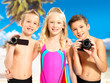 Children with photo and video camera at beach.