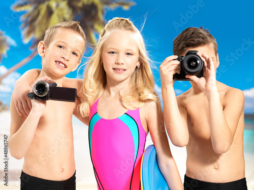Photo: Children with photo and video camera at beach. Children with photo and video camera at beach.