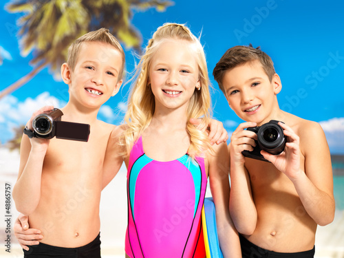 Photo: Children with photo and video camera at beach. Children with photo and video camera at beach.