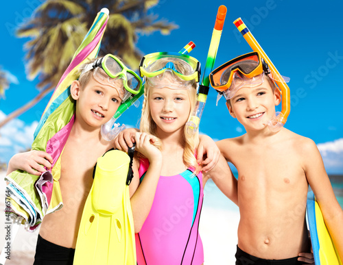 Photo: Portrait of the happy children enjoying at beach Portrait of the happy children enjoying at beach