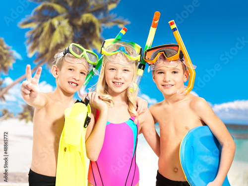Photo: Portrait of the happy children enjoying at beach Portrait of the happy children enjoying at beach
