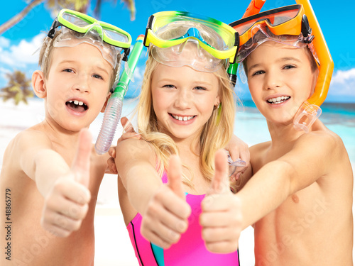 Photo: Happy children with thumbs-up gesture at beach Happy children with thumbs-up gesture at beach