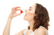 Young woman eatting candy heart isolated