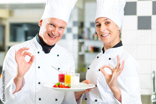 Photo: Chef team in restaurant kitchen with dessert Chef team in restaurant kitchen with dessert