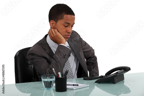 Photo: Businessman staring at telephone Businessman staring at telephone