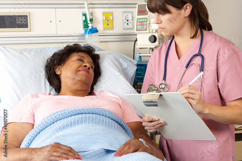Photo: Nurse Visiting Senior Female Patient On Ward Nurse Visiting Senior Female Patient On Ward